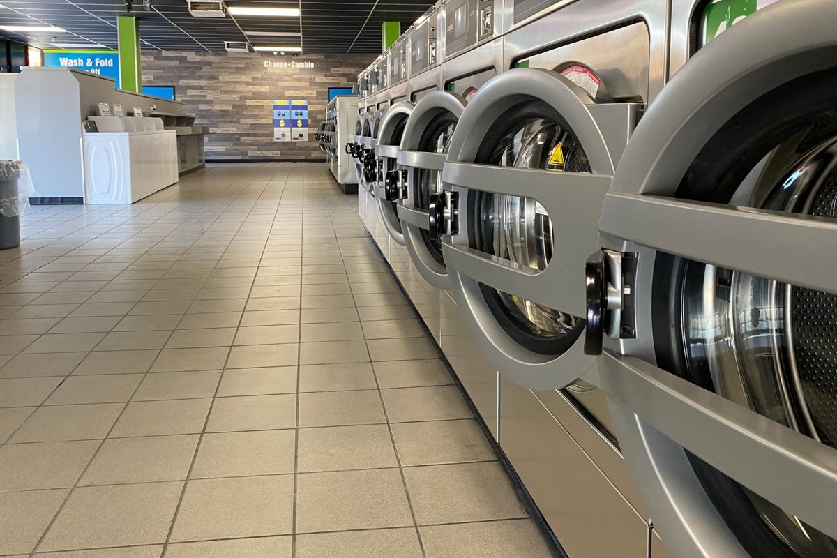 Inside a Half Price Laundry laundromat: a clean aisle of large-capacity front-load washers